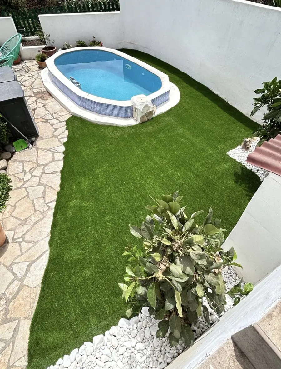 Jardín con césped artificial y piscina