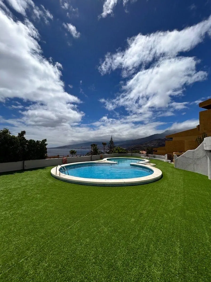 Zona de piscina con césped artificial